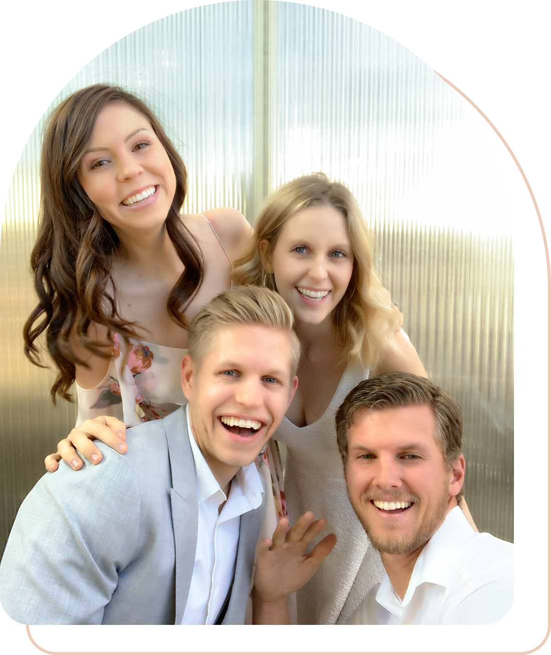 Four friends smiling together in a bright, cheerful setting.