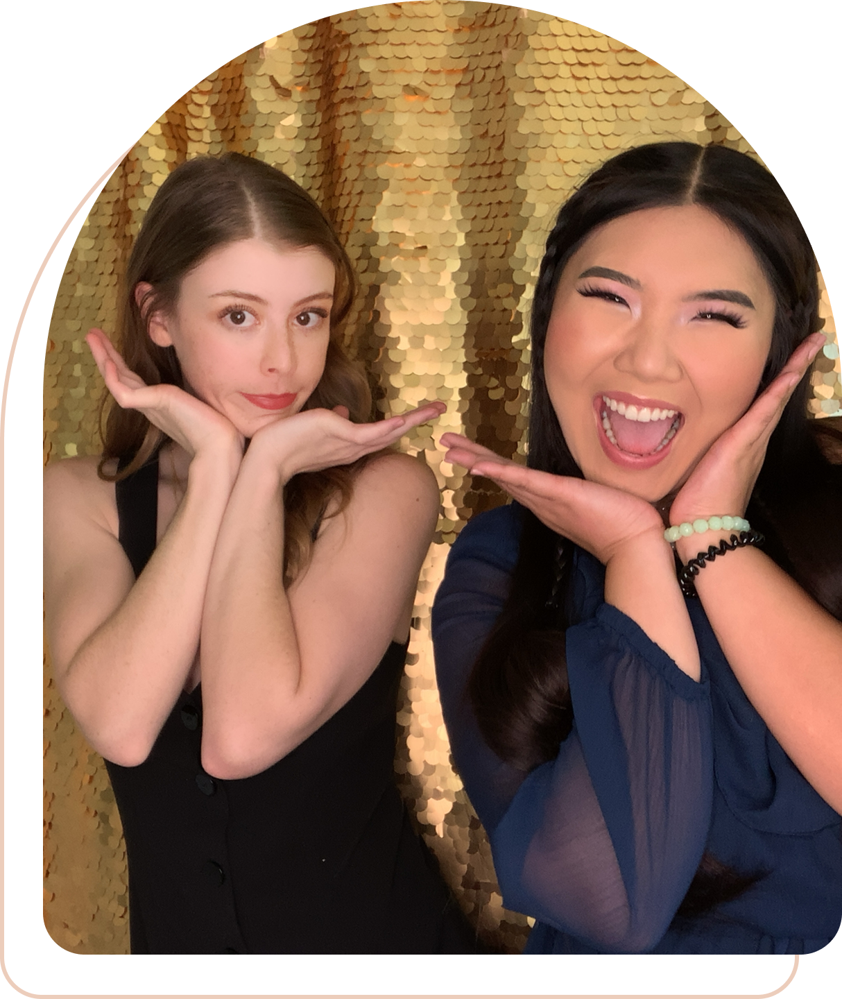 Two joyful women posing in front of a shimmering gold backdrop.